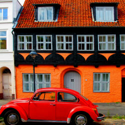 Пазл: Красный автомобиль перед оранжевым домом